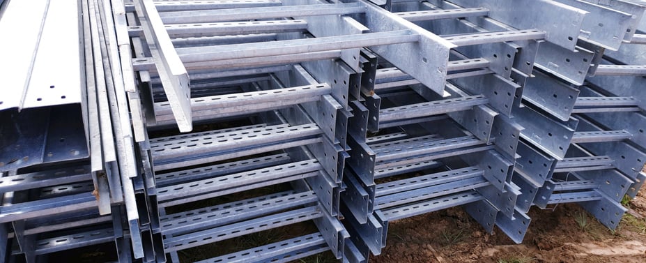 Stacked galvanized steel strut channels arranged on the ground, used for industrial structural support and framing applications.